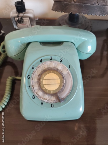 Foto Vintage teal rotary dial telephone on table.