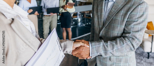 White executive finalizing contract with firm handshake