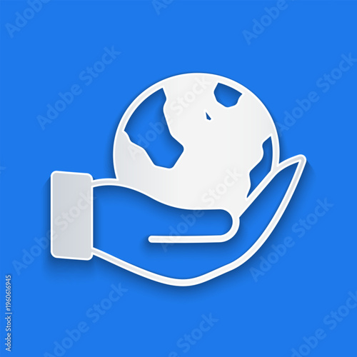 Paper cut Human hand holding Earth globe icon isolated on blue background. Save earth concept. Paper art style. Vector