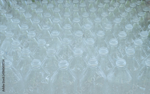 Several empty clear plastic bottles with no caps were stacked in a row.
