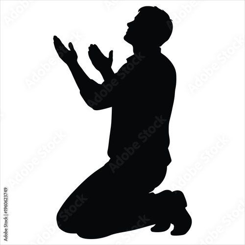 A man kneels in prayer with hands raised
