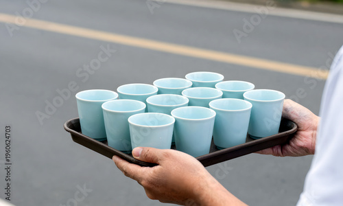 Wallpaper Mural Person holding tray with multiple blue cups at roadside for marathons   Torontodigital.ca