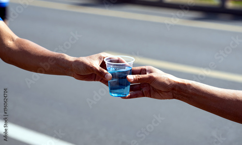 Wallpaper Mural Hands passing water cup during marathon on outdoor road background   Torontodigital.ca