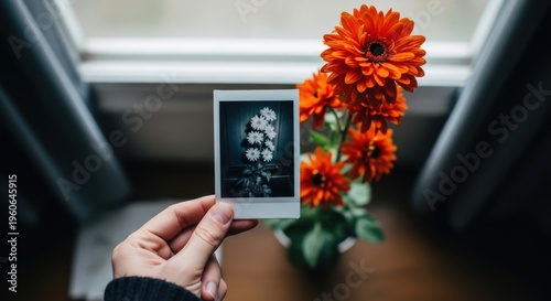 Hand holding instant photo of flowers
