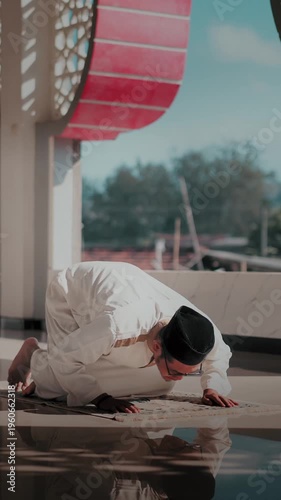 A Muslim man performing Islamic pray inside a mosque during Ramadan, a peaceful spiritual moment with beautiful mosque architecture.