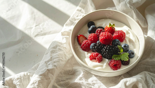 新鮮なミックスベリーを添えたヨーグルトボウル 明るい朝の光と文字入れ用余白のあるヘルシーな背景素材