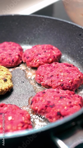 Close-up of homemade plant-based beetroot burgers frying with oil bubbles