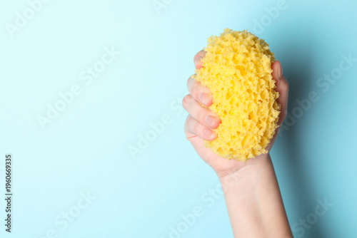 Bild auf Leinwand Woman with bath sponge on light blue background, closeup