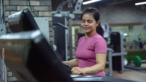 Indian Woman Using Treadmill During Cardio Workout in Modern Gym