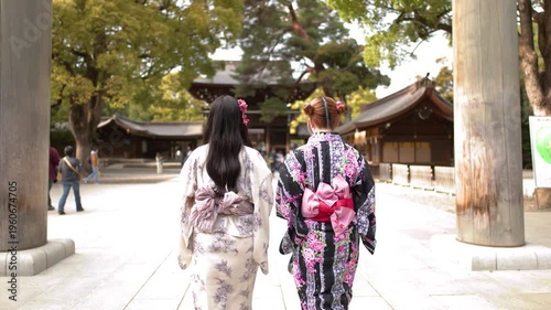 Two Women in Traditional Kimonos Walking Through Meiji Jingu Shrine Torii Gate