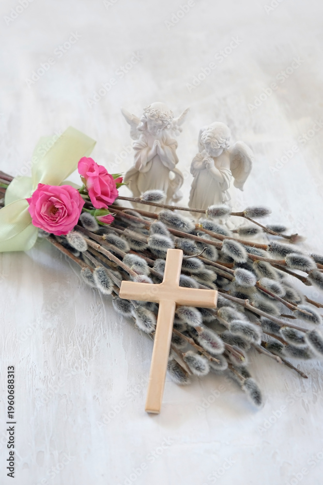 Naklejka premium Easter and Palm Sunday holiday background. Bouquet of pussy willow and roses, wooden cross, angel figurines on light table close up. symbol of Easter, prayer, faith, orthodox Church, religion concept