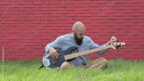 Bearded musician playing electric bass guitar