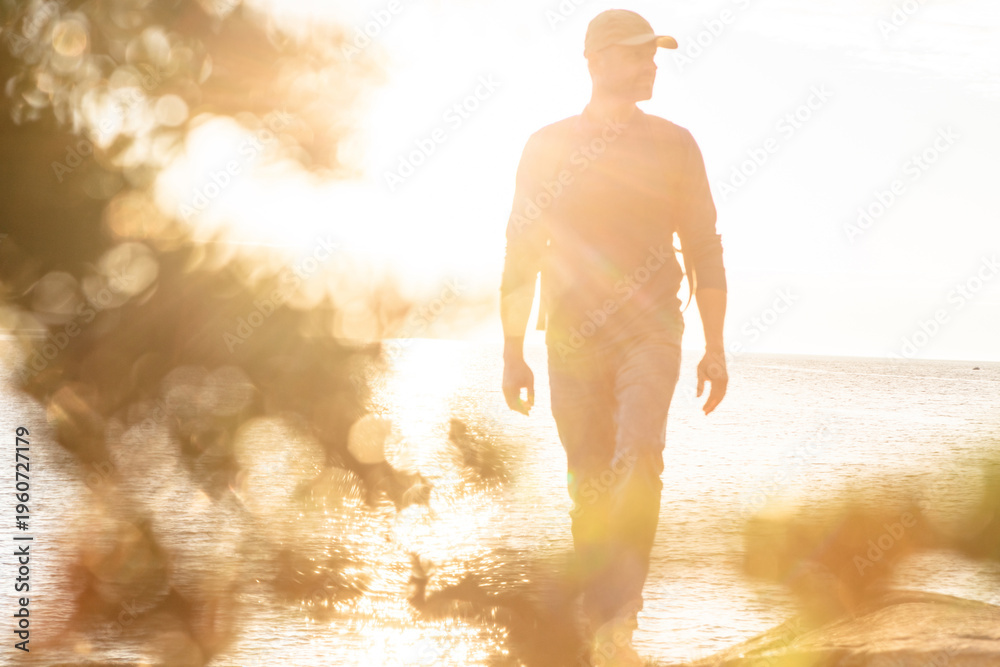 Naklejka premium Hiking, summer and walk with man in nature for trekking adventure, backpacking and seaside trail. Environment, travel vacation and sunshine with person or hiker outdoor for ocean, explore and flare