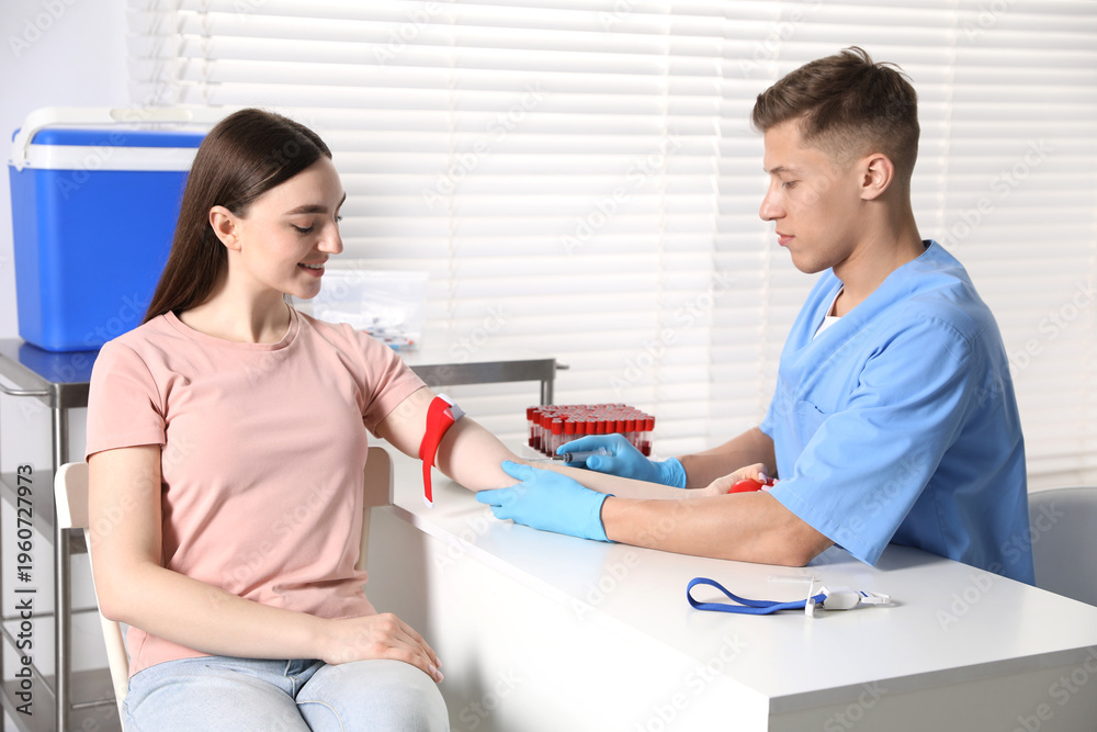 Obraz premium Nurse drawing woman's blood sample in clinic