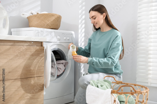 Obraz na płótnie Woman adding detergent into washing machine at home
