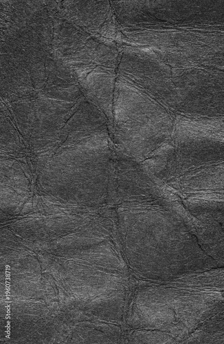 Black crumpled wrinkled paper background or backdrop with fine details and texture with copy space for text design element