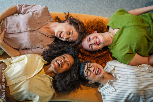 Fotografía Diverse women friends lying together laughing in a circle