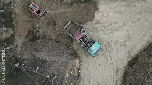 construction is dependent on transport movement materials. hand dump loader container truck during park construction. piles of dirt, preparation of  leveling soil rubble from previous building that wa