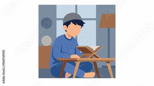 A young Muslim boy in blue attire and a kufi sits on the floor, reading from a holy book on a rehal placed on a low wooden table in a room, depicting a moment of religious study.