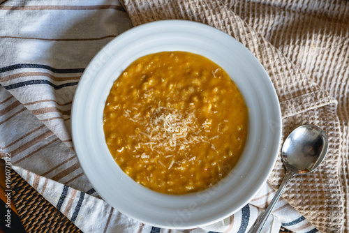 Homemade chicken pastina soup with grated parmesan cheese in white bowl