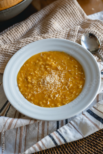Homemade chicken pastina soup with grated parmesan cheese in white bowl
