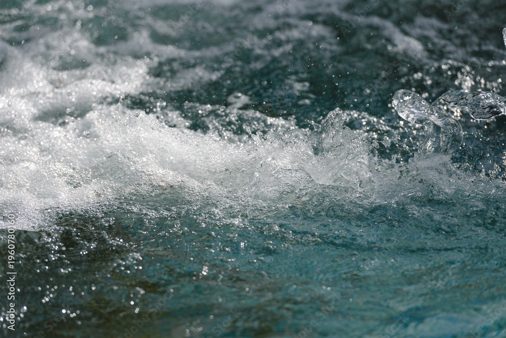 Obraz premium Close-up of water splashes with white foam on the surface, background, texture