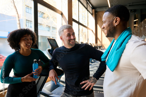 Diverse friends laughing and talking at fitness gym