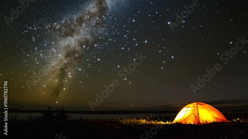 Glowing tent at night under a starry sky with the Milky Way visible