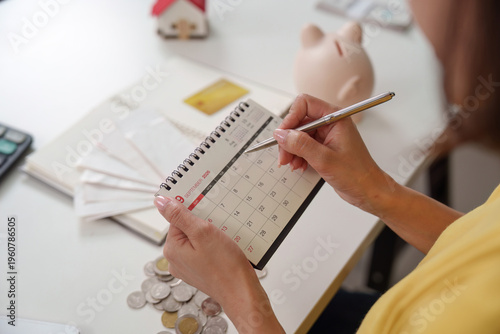 Marking financial goals on a calendar with coins and documents