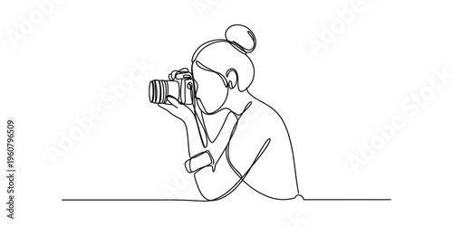 Continuous line drawing of a female photographer holding a professional camera to her eye