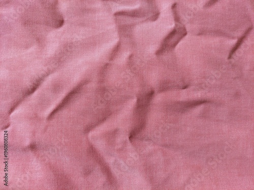 Pink fabric texture pattern for soft textile background. Crumpled pink cloth material surface for clothing or fashion design.