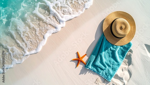 Aerial top-down view of a stylish turquoise beach towel on pristine white sand near the ocean