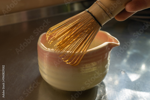 bamboo whisk next to ceramic bowl