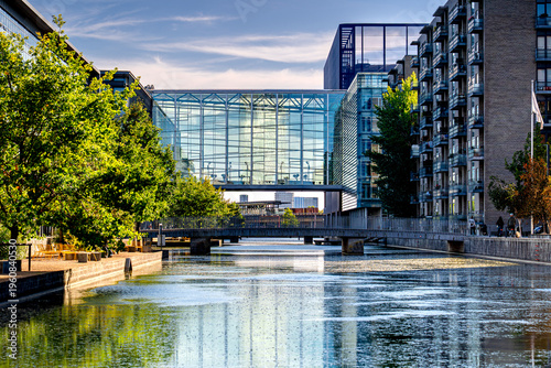 Close-up of glass facade building in academic district with people, daily life in Copenhagen, Danish architecture.