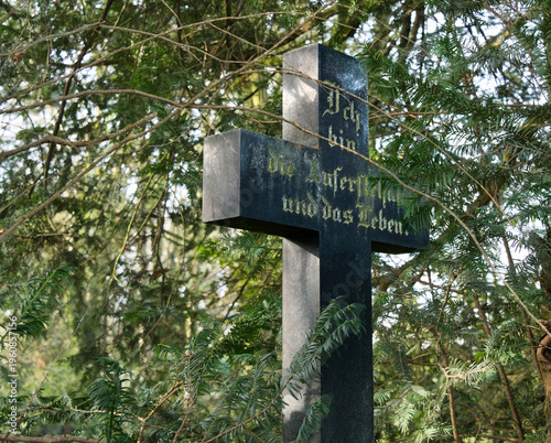 schwarzes Kreuz mit einem frommen Bibelspruch auf einem Friedhof in Unna