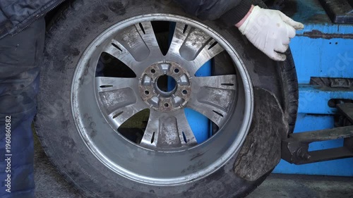 Mechanic removes car tire from wheel using tire changing machine in workshop. Auto repair, maintenance service and automotive industry concept. High quality 4k footage