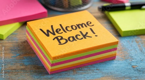 Colorful Sticky Notes with Welcome Back Message on Wooden Table in an Office Workspace