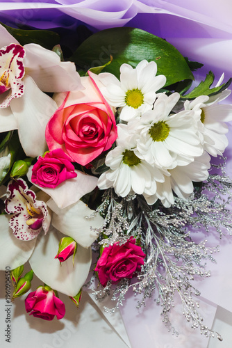 Background for floral arrangement. Beautiful fragrant bouquet with roses, daisies and orchids. Floristry and floral design concept. Floral texture close-up.