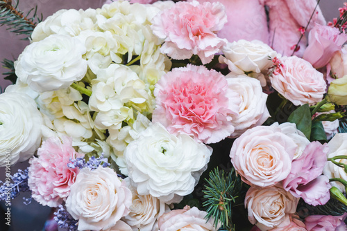 Romantic gift. Bouquet of flowers decorated with spruce branches. Flower arrangement of roses, carnations and hydrangeas.