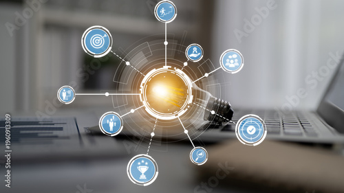 Photos A modern workspace featuring a laptop and a light bulb surrounded by digital icons
