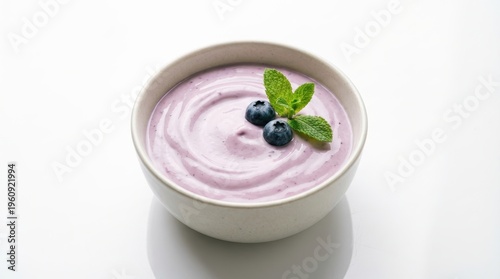 Creamy Blueberry Yogurt with Fresh Mint Leaves Served in a Stylish Bowl on White Background