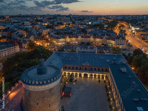 Stare Miasto w Lublinie nocą z oświetlonymi ulicami, Zamkiem i Wieżą Trynitarską, widok z drona