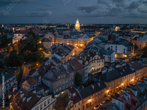 Stare Miasto w Lublinie nocą z oświetlonymi ulicami, Zamkiem i Wieżą Trynitarską, widok z drona