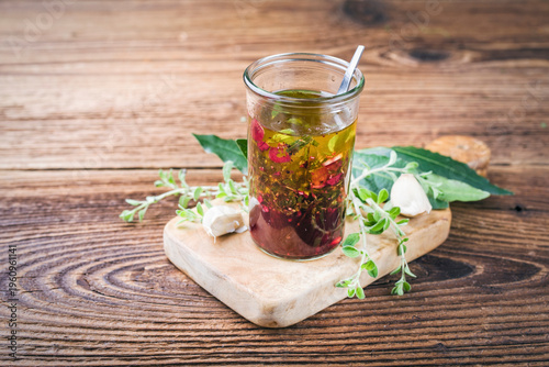 Homemade green herbs Mediterranean marinade for grilling made of olive oil, fresh herbs, bay leaf, red wine vinegar, garlic and spices