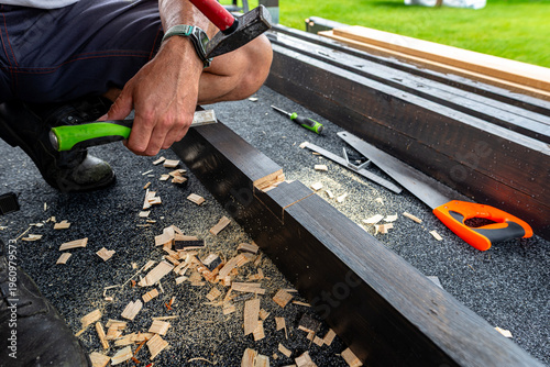 Quadro em tela Carpenter cutting mortise joint in wooden beam for terrace construction