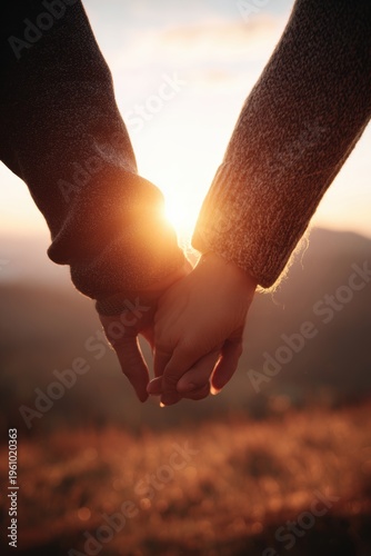 Wallpaper Mural Lovely couple romantic moment. Two people holding hands against a backdrop of a setting sun, with the sun casting a warm, golden light over them. The person on the left wears a sweater. Torontodigital.ca