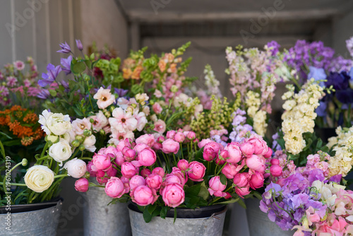Buckets of colourful flowers for sale at florists