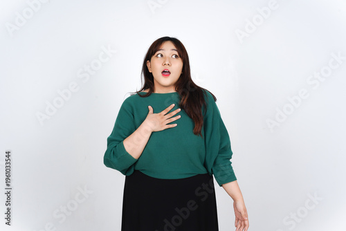 Bild auf Leinwand Surprised Young Asian Woman Looking Up With Hand On Chest