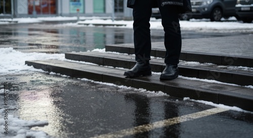 Person walking on wooden planks in a snowy parking lot.