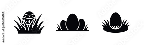 Set of three black silhouette icons depicting Easter eggs nestled in grass, perfect for spring holiday designs and minimalist festive graphics.